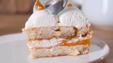 İnsan kaşığı lezzetli ev yapımı meyveli pasta yemek için kullanır..