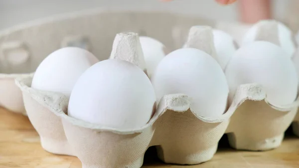 Hand nimmt einen aus im Karton verpackten Eiern — Stockfoto