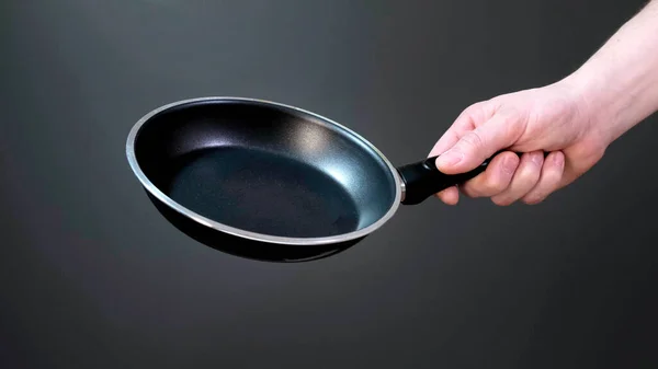 Hands holding new empty black frying pan. Close up. — Stock Photo, Image