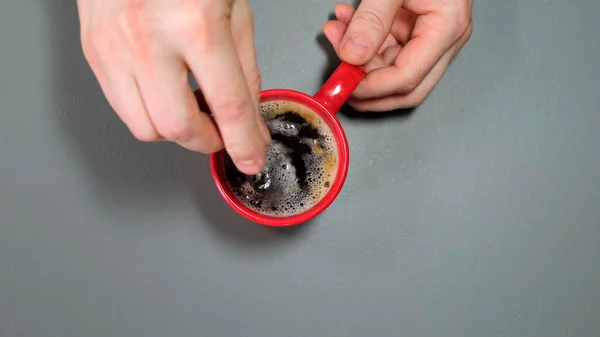 Vue du dessus de la main de la personne en remuant le café avec une cuillère. Gros plan . — Photo