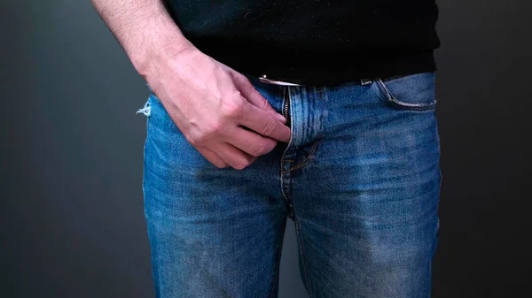 Man in black fastens his blue jeans. Close up. — Stock Photo, Image