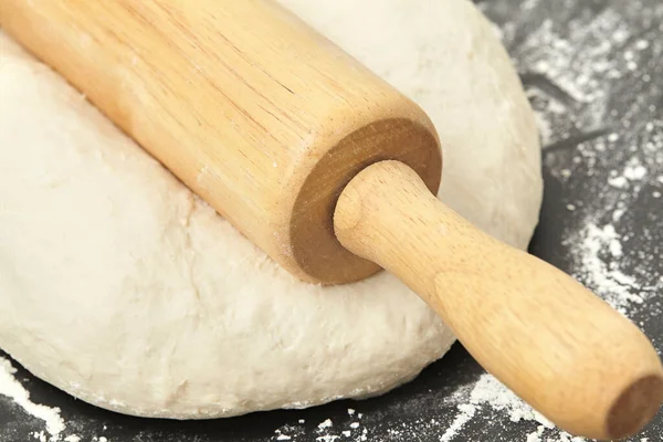 Dough and wood rolling pin on clean black background Close up — Stock Photo, Image