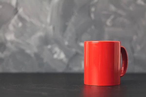 Piros csésze szürke háttér ron fekete asztal. Fénymásolási hely — Stock Fotó