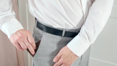 Deri cüzdanı alıp para çıkaran bir adam.