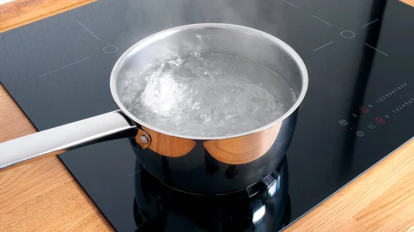Kippeneieren kokend in roestvrijstalen pan in water. — Stockfoto