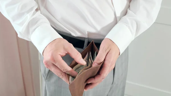 Hombre tomando cartera de cuero y saca dinero —  Fotos de Stock