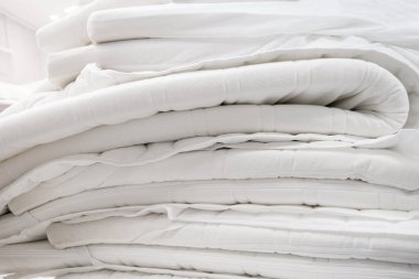 Odada bir yığın beyaz yatak var. Kapat.