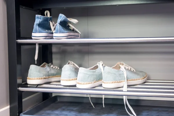 Shelving rack with shoes in hallway indoors — Stock Photo, Image