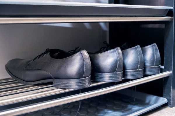 Shelving rack with shoes in hallway indoors — Stock Photo, Image