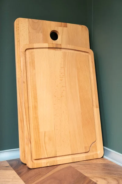 Tabla de cortar de madera vacía de pie sobre una mesa de cocina. De cerca. — Foto de Stock