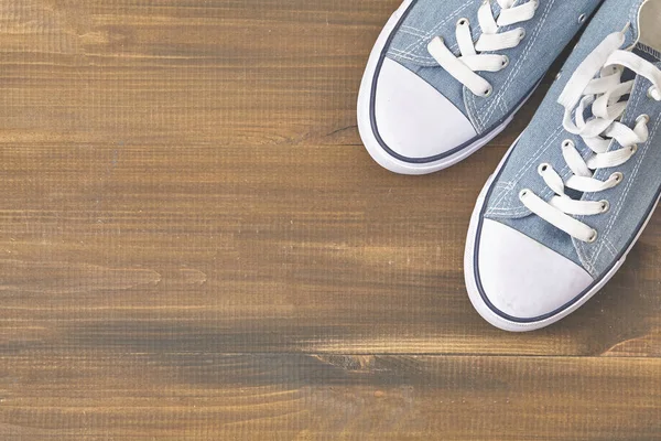 Blue sneakers on wooden background with copy space. Top view. — Stock Photo, Image