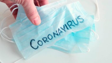 Masa Maskesi Tıbbi Koruması 'na kelime Coronavirus ile elle yerleştirildi. Kapat..