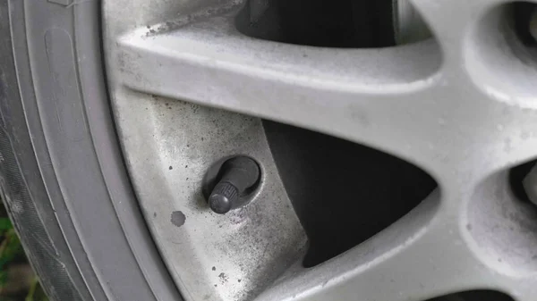 Hand twists the cap nipple car wheel. — Stock Photo, Image
