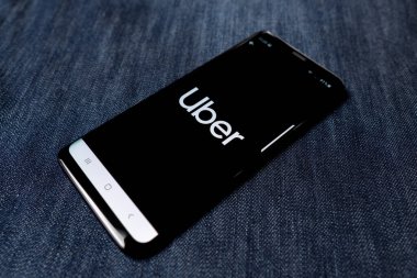 Odessa, Ukrayna - 26 Ekim 2019: Uber uygulaması. Uber logosu akıllı telefon ekranında görünüyor. Denim geçmişi. Yumuşak odak