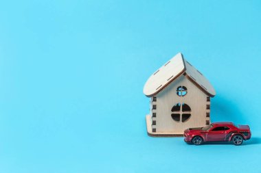 Odessa, Ukrayna - 17 Kasım 2019: Mavi arka planda oyuncak ahşap ev ve kırmızı araba