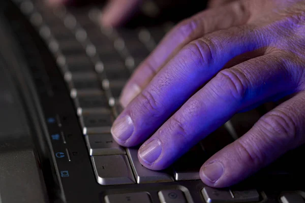 A man works at a computer. Hands of a man on the keyboard close-up. Programmer or hacker. Soft focus