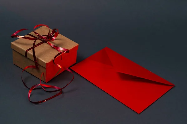 Gift box and red mail envelope on a gray background. Red backlight