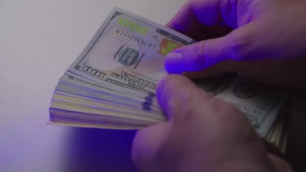 The man counts the money. Counting 100 dollar banknotes on a white table. Close up — 비디오