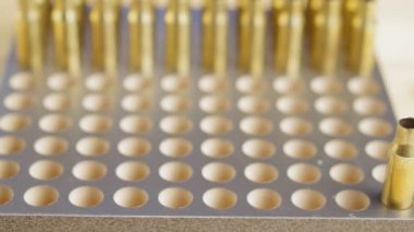 Tüfek için şarjör üretimi, yeniden doldur. Adam boş fişekleri tezgaha koyar.