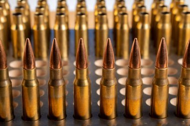 Production of cartridges for a rifle, reload. Empty shells and ammunition. Close up clipart