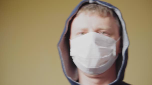 Man met een medisch masker en een capuchon, sluiten. Pandemische COVID-19 — Stockvideo