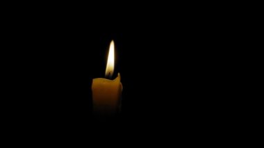 Mum alevi karanlıkta rüzgarda sallanıyor.