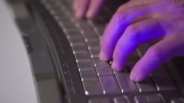 Een man die achter een computer werkt. Mannelijke handen en computer toetsenbord close-up. Zijaanzicht — Stockvideo