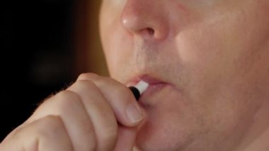 Adam e-sigara içiyor, yakın plan.