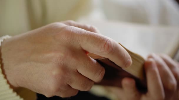 Man leest oud boek, close-up met handen, zijaanzicht. Zachte focus — Stockvideo