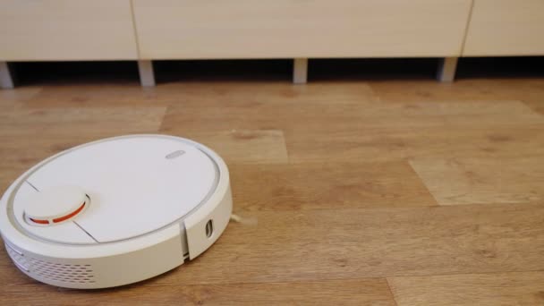 Robot vysavač na dřevěné podlaze v místnosti — Stock video