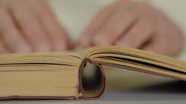 homme lit un livre et tourne pages gros plan 