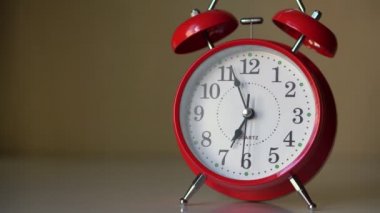 Beyaz bir komodindeki kırmızı çalar saat. Saat işliyor Zaman ilerliyor