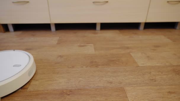 Aspirapolvere robot su un pavimento in legno in una stanza, vista laterale — Video Stock