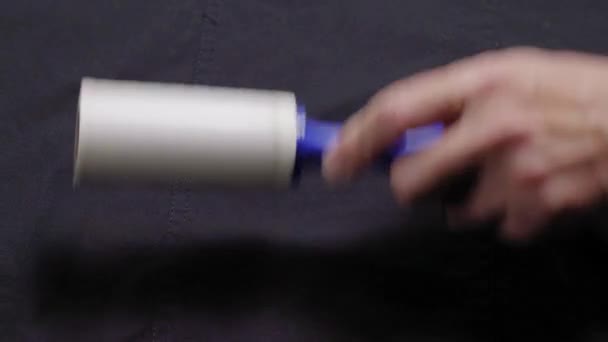 Someone is cleaning clothes with a cleaning roller, hands of a man close-up with a roller for cleaning clothes — Stock Video