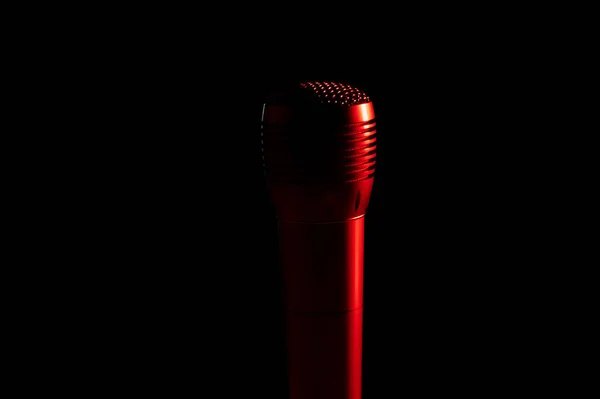 Ljud mikrofon på ett stativ i en svart mörk bakgrund, röd bakgrundsbelysning — Stockfoto