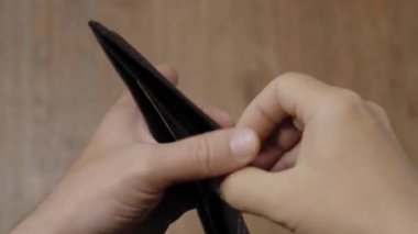 Elinde bir dolar olan siyah deri bir cüzdan. İflas ve Yoksulluk Konsepti