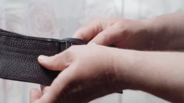 Bir adamın elinde boş deri cüzdan, yakın plan. Yoksulluk kavramı