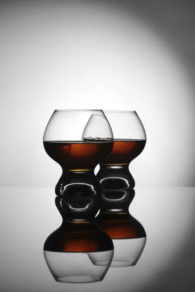 Twee glazen met cognac op grijze achtergrond — Stockfoto