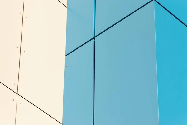 Geometric color elements of the building facade with planes, lines, corners with highlights and reflections for the abstract background and texture of blue, turquoise, white, gray colors. Place for text