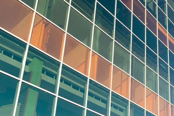 Glass transparent windows on the facade of a modern high-rise office or commercial building in the center of a big city reflect the blue sky