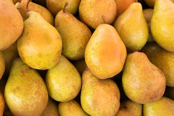 Yellow ripe pears lined up for sale in a supermarket