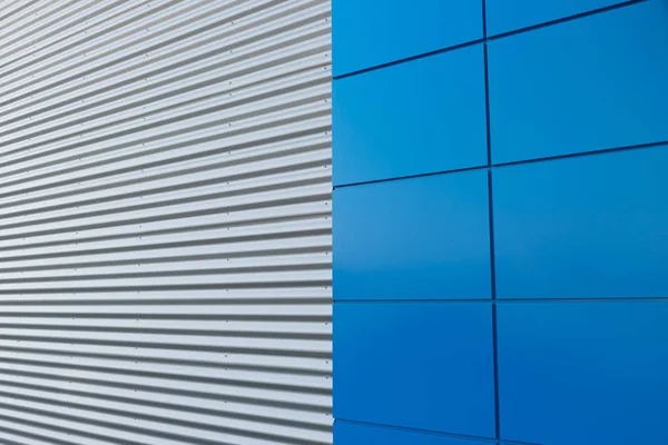 Geometric colored building facade elements with planes, lines and corners with light flare and reflections for an abstract background and texture of white, blue, gray colors. Place for text