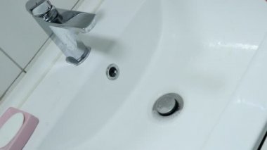 Banyodaki lavaboyu temizliyorum.