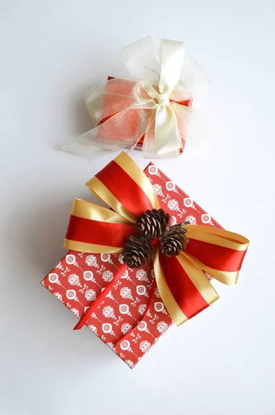 漂亮的红盒和圣诞礼物 放在红色盒子里 上面有白球的图案 红色盒子 白色背景 准备度假吧 圣诞快乐 新年快乐 用弓形和冷杉圆锥装饰的盒子 — 图库照片