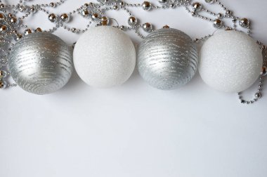 Beyaz arka planda iç dekorasyon için gümüş boncuklar. Tatil için dekorasyon. Mutlu Noeller ve mutlu yıllar. Ve beyaz bir Noel balosu. Noel oyuncağı.