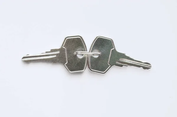 白色背景上的灰色金属钥匙 门锁的钥匙 前门的两把钥匙 — 图库照片