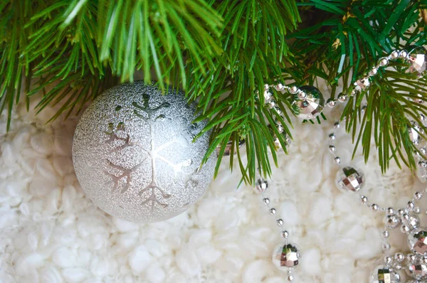 幸せなクリスマスと新年のための装飾 シルバーカラー 白い居心地の良い毛布の上のクリスマスボールとビーズ 幸せな冬の休日 おめでとうございますクリスマスツリーの装飾のための灰色のボール 緑の木の枝 — ストック写真