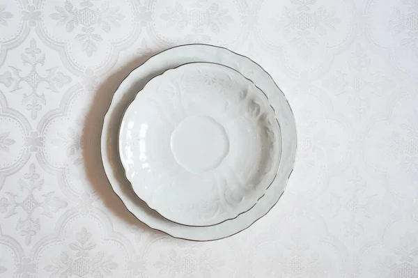 Two white dinner plates on a white background.