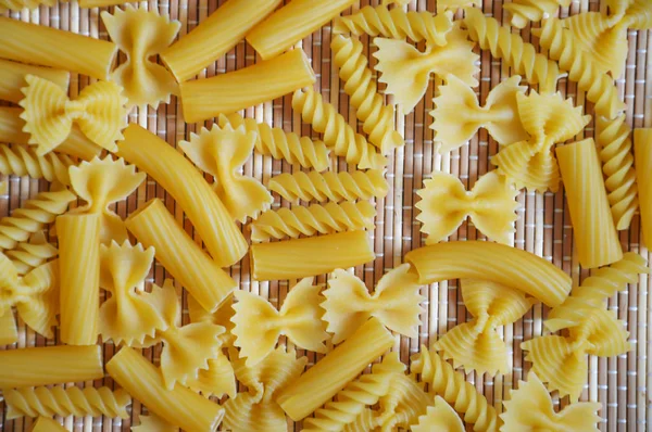 pasta on a straw background. the view from the top. food supply.