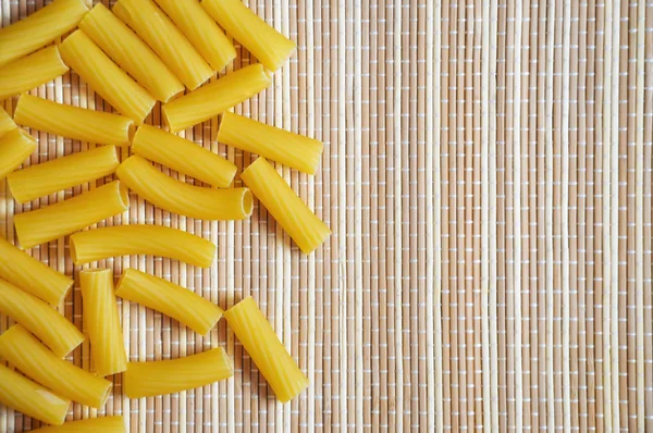 pasta on a straw background. the view from the top. food supply.